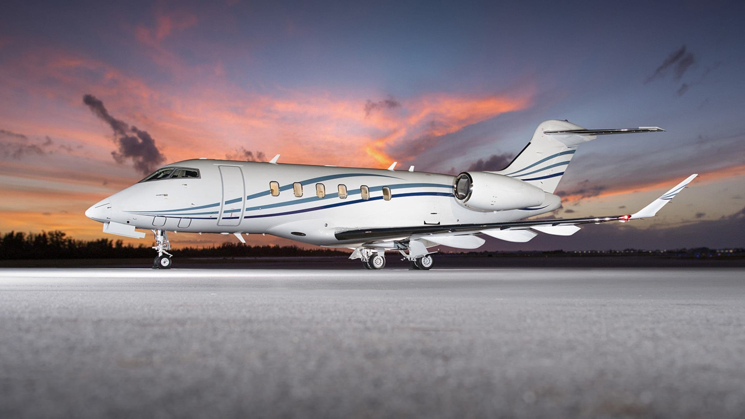 Challenger 350 on the ramp under a sunset sky