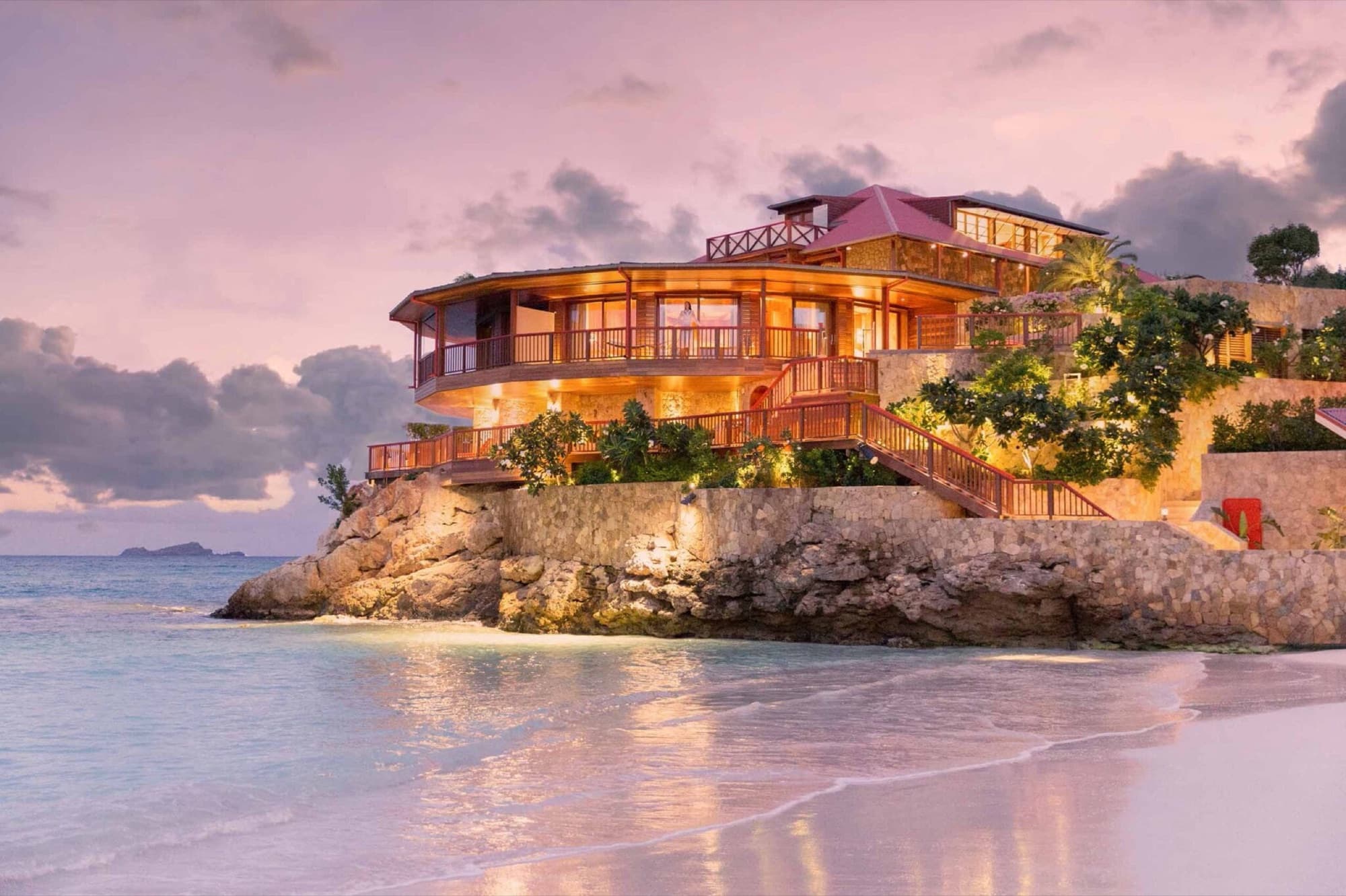 Lamplit clifftop villa above the beach at sunset on St. Barts